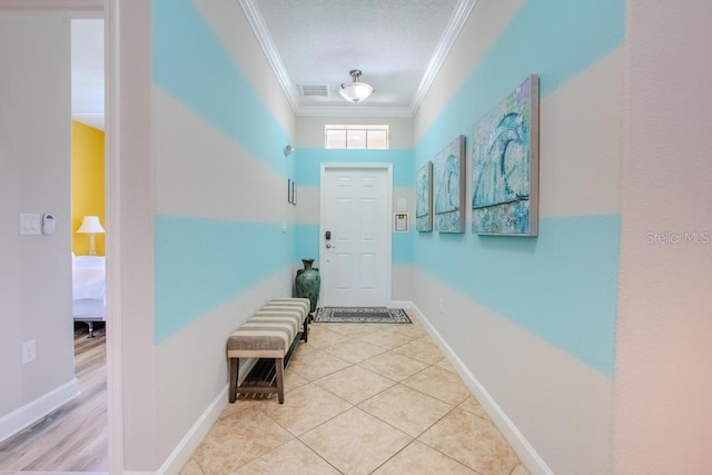 entryway featuring crown molding, baseboards, and tile patterned floors