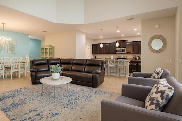 living area featuring light tile patterned flooring, a chandelier, recessed lighting, and a towering ceiling
