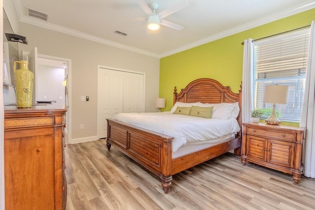 bedroom featuring crown molding, light wood-style floors, a closet, a ceiling fan, and baseboards