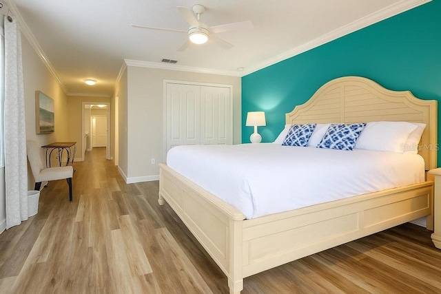 bedroom with wood finished floors, a closet, crown molding, a ceiling fan, and baseboards