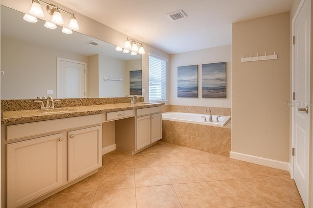 full bathroom featuring tile patterned flooring, a bath, and double vanity