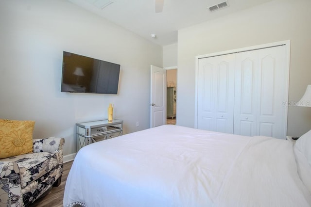 bedroom featuring wood finished floors, a closet, a ceiling fan, and baseboards