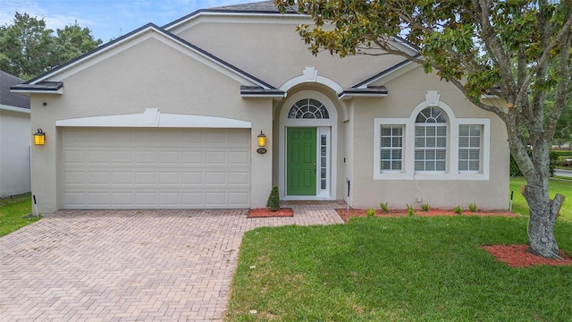 714 Home Grove Dr, Winter Garden, FL 34787 - view of front of house featuring decorative driveway, stucco siding, a front lawn, and a garage