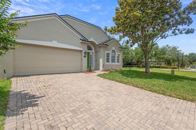 714 Home Grove Dr, Winter Garden, FL 34787 - single story home with stucco siding, a front yard, decorative driveway, and a garage