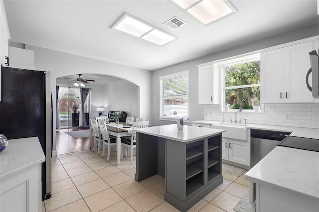 714 Home Grove Dr, Winter Garden, FL 34787 - kitchen with stainless steel appliances, a sink, decorative backsplash, light tile patterned flooring, and white cabinets