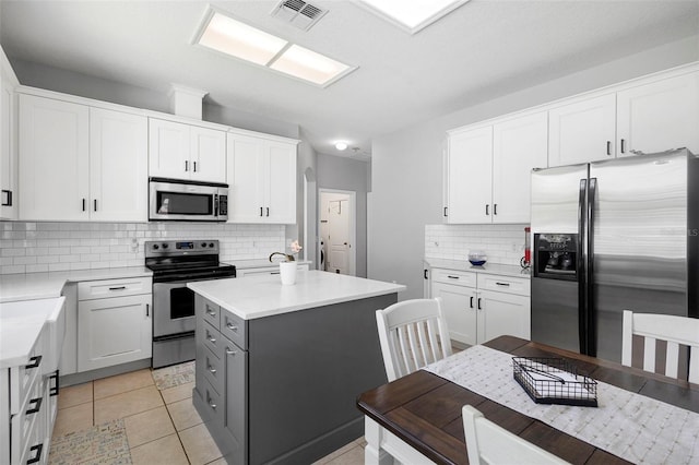 714 Home Grove Dr, Winter Garden, FL 34787 - kitchen featuring appliances with stainless steel finishes, tasteful backsplash, a center island, light countertops, and white cabinets