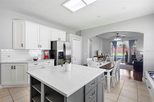 714 Home Grove Dr, Winter Garden, FL 34787 - kitchen with stainless steel fridge, arched walkways, a ceiling fan, open shelves, and a kitchen island