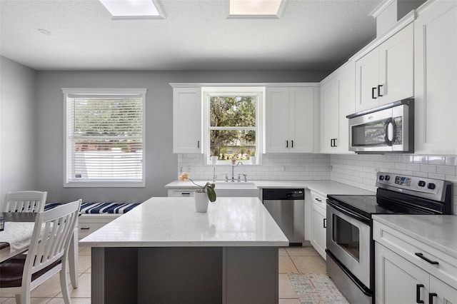 714 Home Grove Dr, Winter Garden, FL 34787 - kitchen featuring stainless steel appliances, light tile patterned flooring, decorative backsplash, and a textured ceiling