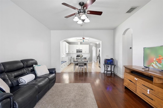 714 Home Grove Dr, Winter Garden, FL 34787 - living area featuring arched walkways, ceiling fan, light wood-style floors, and baseboards