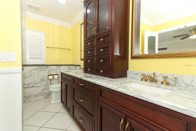 645 Peachwood Dr, Altamonte Springs, FL 32714 - bathroom featuring crown molding, double vanity, tile walls, a wainscoted wall, and tile patterned floors