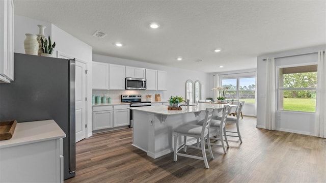 4246 Acoma Dr, Ormond Beach, FL 32174 - kitchen with stainless steel appliances, dark wood-style floors, a breakfast bar, light countertops, and decorative backsplash