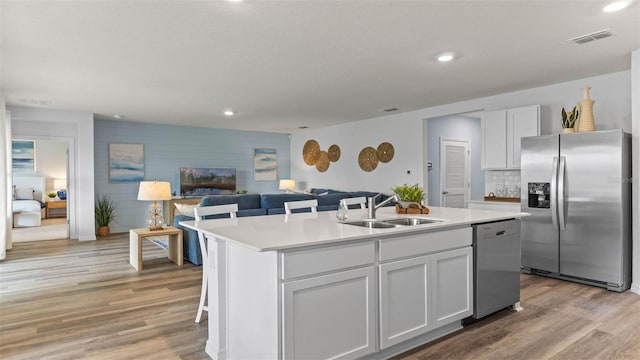 4246 Acoma Dr, Ormond Beach, FL 32174 - kitchen featuring stainless steel appliances, a sink, light wood finished floors, a kitchen island with sink, and recessed lighting