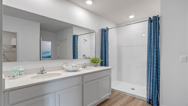 4246 Acoma Dr, Ormond Beach, FL 32174 - bathroom featuring tiled shower, wood finished floors, and double vanity