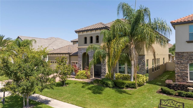 8419 Pippen Dr, Orlando, FL 32836 - mediterranean / spanish home featuring stone siding, stucco siding, a tile roof, and a front yard