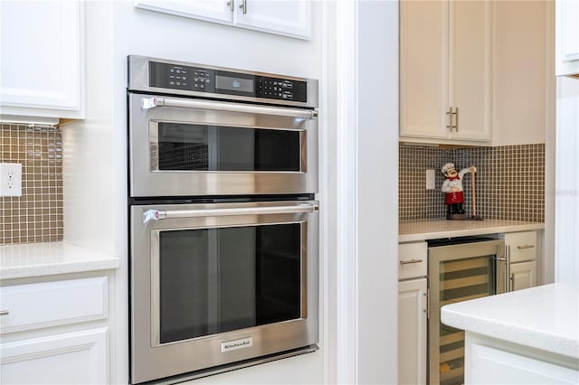 8419 Pippen Dr, Orlando, FL 32836 - kitchen featuring double oven, wine cooler, white cabinetry, and backsplash