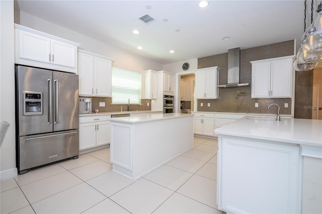 8419 Pippen Dr, Orlando, FL 32836 - kitchen with stainless steel appliances, wall chimney range hood, a kitchen island, tasteful backsplash, and a sink