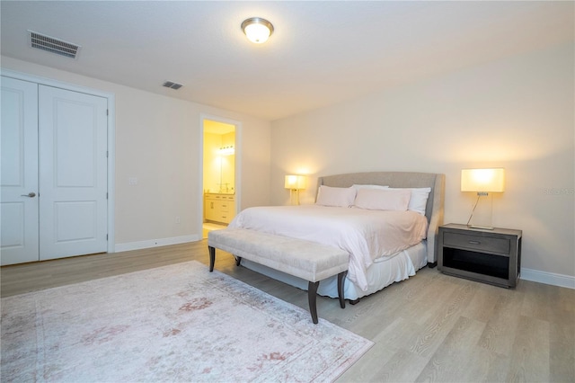 8419 Pippen Dr, Orlando, FL 32836 - bedroom with light wood-style flooring, baseboards, and connected bathroom