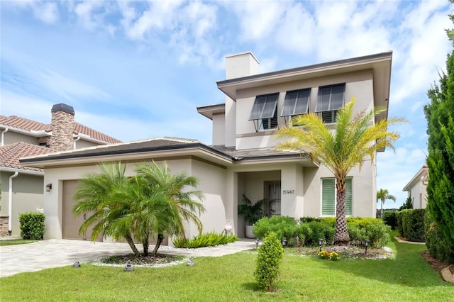 15947 Vetta Dr, Bella Collina, FL 34756 - view of front of house with stucco siding, a front lawn, concrete driveway, and a garage
