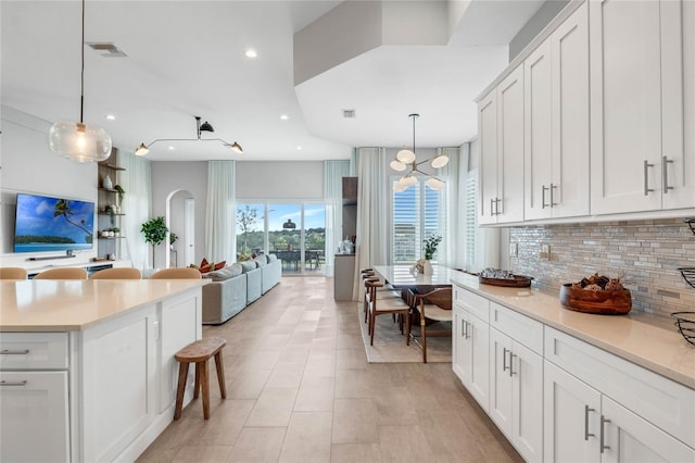 15947 Vetta Dr, Bella Collina, FL 34756 - kitchen featuring decorative backsplash, light countertops, recessed lighting, and white cabinets