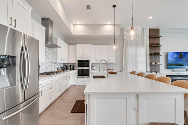 15947 Vetta Dr, Bella Collina, FL 34756 - kitchen featuring appliances with stainless steel finishes, a sink, wall chimney exhaust hood, backsplash, and recessed lighting