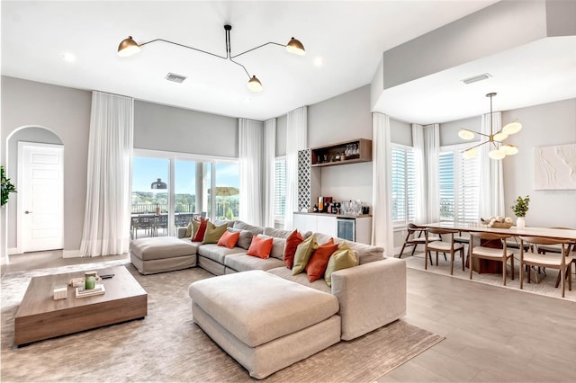 15947 Vetta Dr, Bella Collina, FL 34756 - living room featuring a chandelier, plenty of natural light, wine cooler, and recessed lighting