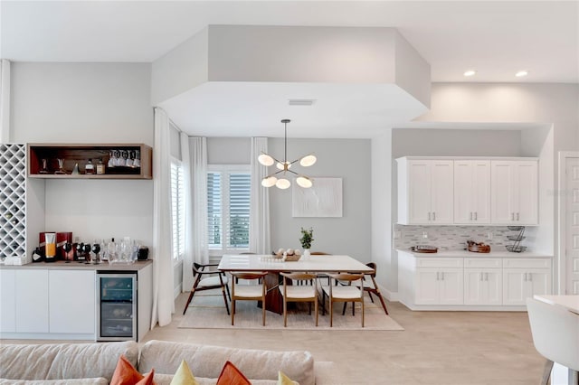 15947 Vetta Dr, Bella Collina, FL 34756 - dining room featuring beverage cooler, a chandelier, a dry bar, recessed lighting, and light wood finished floors
