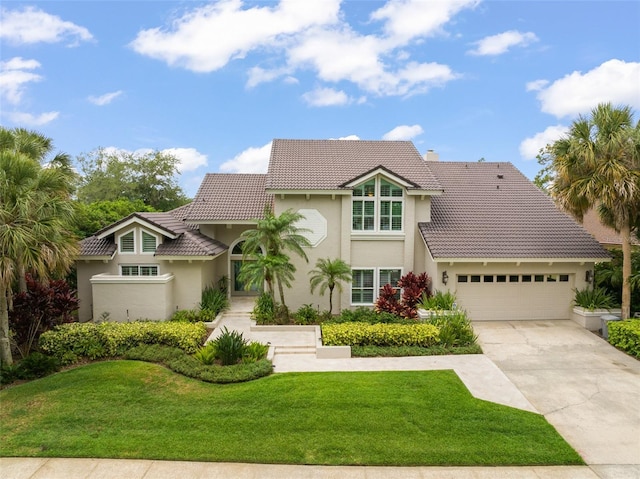 4536 N Landmark Dr, Orlando, FL 32817 - view of front of property featuring stucco siding, a tiled roof, a garage, and a front lawn