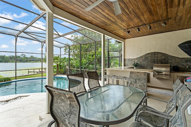 4536 N Landmark Dr, Orlando, FL 32817 - view of patio / terrace with an outdoor kitchen, a ceiling fan, a water view, an outdoor pool, and outdoor dining space