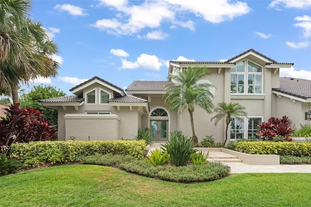 4536 N Landmark Dr, Orlando, FL 32817 - mediterranean / spanish-style house featuring french doors, stucco siding, a front yard, and a tile roof