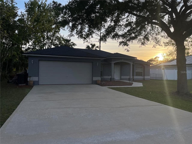 single story home featuring a garage, driveway, and stucco siding