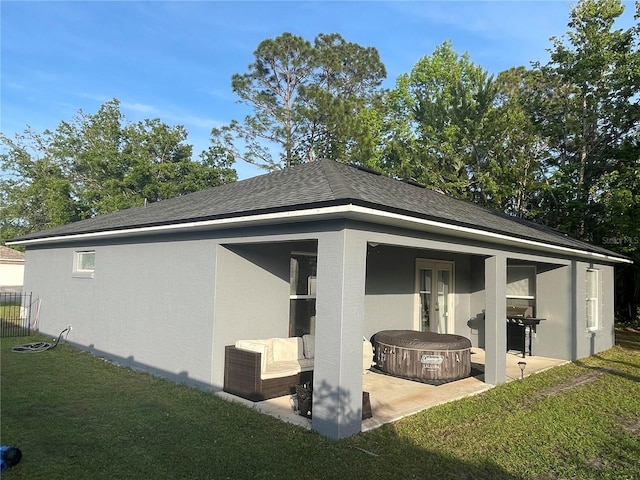view of side of property featuring a patio and a shingled roof