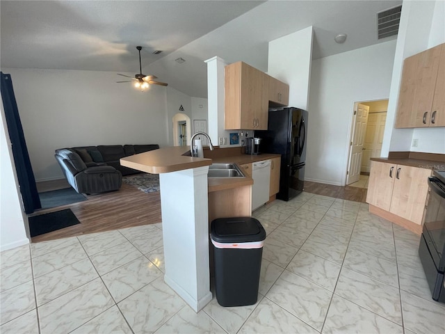 kitchen with a sink, a peninsula, open floor plan, light marble finish floors, and dishwasher