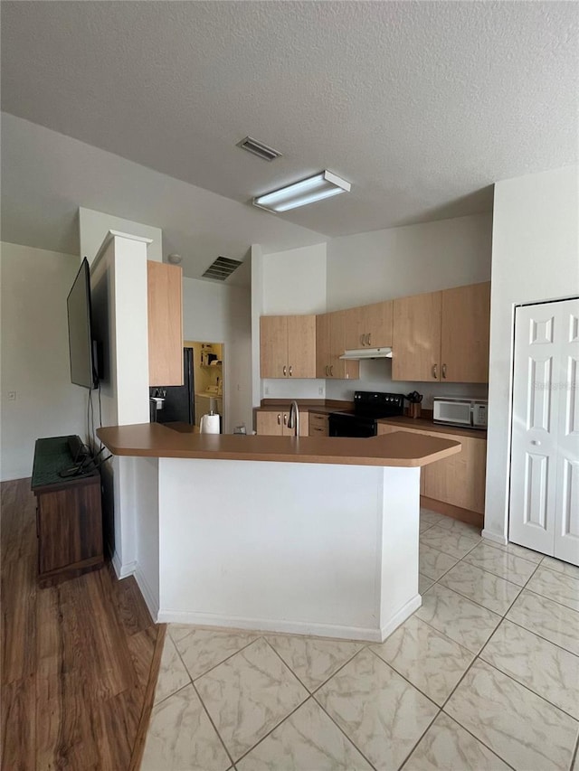 kitchen featuring electric range, vaulted ceiling, a peninsula, a textured ceiling, and white microwave