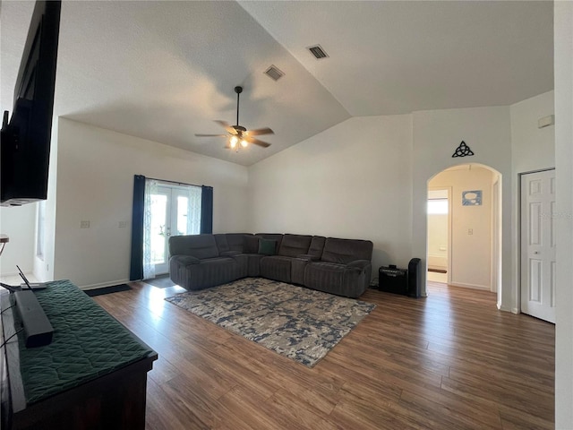 living area featuring arched walkways, ceiling fan, lofted ceiling, wood finished floors, and french doors