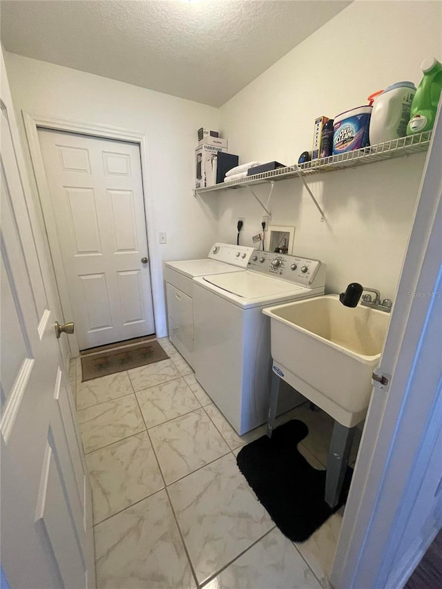 washroom with light marble finish floors, separate washer and dryer, and a textured ceiling