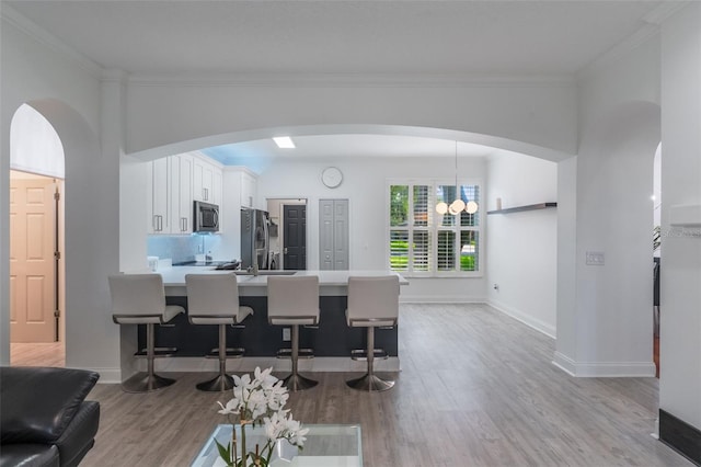 920 Cool Springs Cir, Ocoee, FL 34761 - living room with wood finished floors, crown molding, arched walkways, and baseboards
