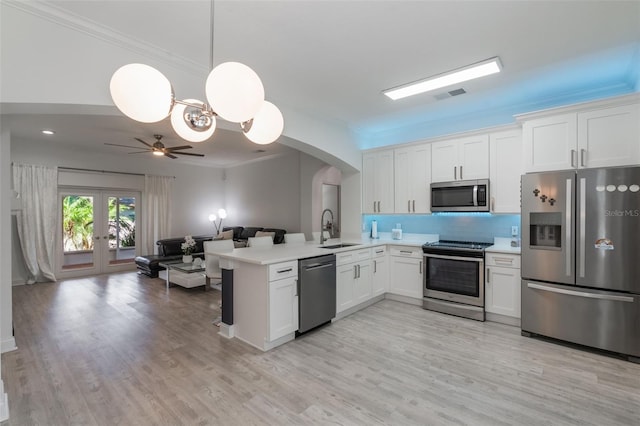 920 Cool Springs Cir, Ocoee, FL 34761 - kitchen with stainless steel appliances, arched walkways, open floor plan, white cabinetry, and crown molding