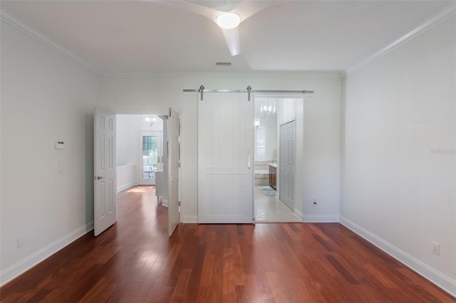 920 Cool Springs Cir, Ocoee, FL 34761 - unfurnished bedroom with wood finished floors, crown molding, baseboards, a barn door, and ensuite bath