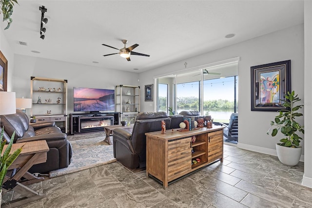 15208 Lake Claire Overlook Dr, Winter Garden, FL 34787 - living room with baseboards, a ceiling fan, and a glass covered fireplace