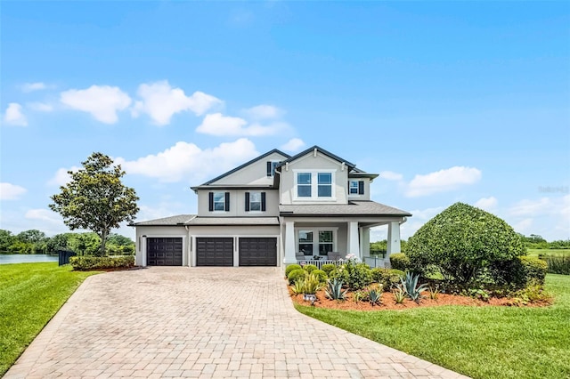 15208 Lake Claire Overlook Dr, Winter Garden, FL 34787 - view of front of house featuring a porch, stucco siding, decorative driveway, a front yard, and a garage