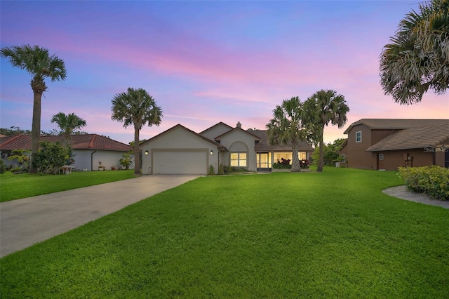 ranch-style house featuring concrete driveway, stucco siding, a front lawn, and a garage