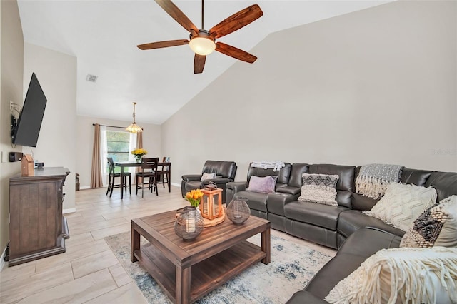 living room featuring a ceiling fan, vaulted ceiling, and baseboards