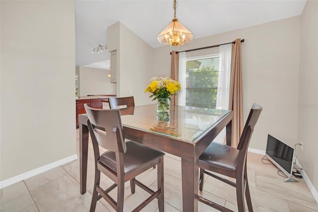 dining area with a chandelier, light marble finish flooring, and baseboards
