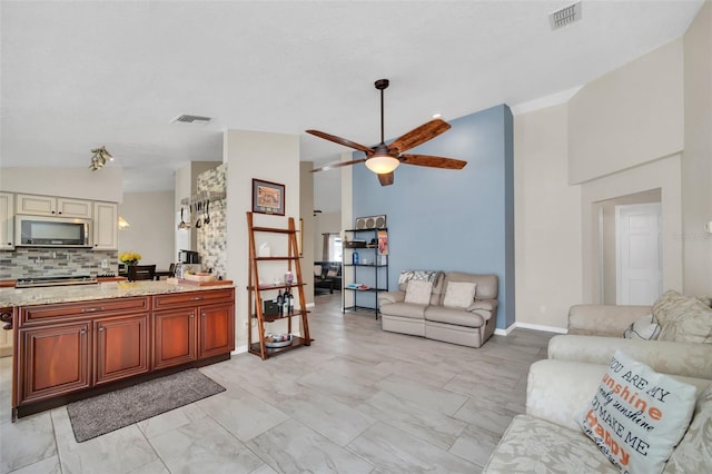 living area with a ceiling fan, high vaulted ceiling, light marble finish flooring, and baseboards