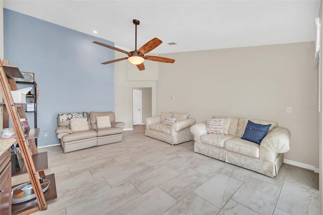living area featuring ceiling fan, baseboards, and marble look tile flooring