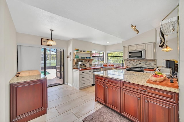 kitchen featuring stainless steel appliances, tasteful backsplash, plenty of natural light, pendant lighting, and lofted ceiling