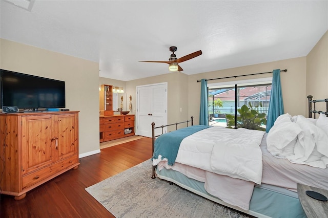 bedroom featuring dark wood-style flooring, access to outside, a ceiling fan, a closet, and baseboards