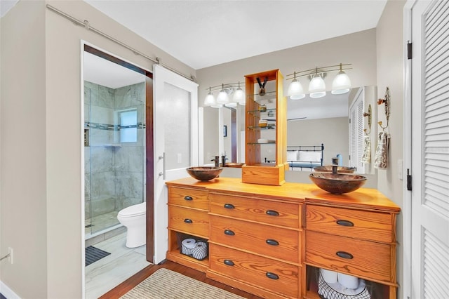 full bath with a stall shower, toilet, and double vanity