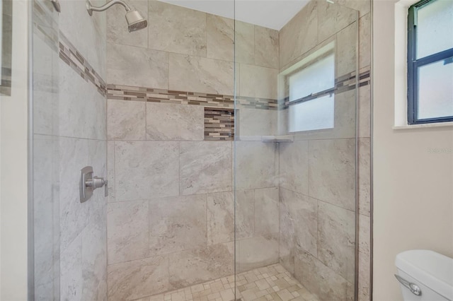 full bath featuring toilet, tiled shower, and healthy amount of natural light