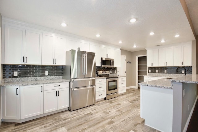 2320 Wekiva Ridge Rd, Apopka, FL 32712 - kitchen featuring appliances with stainless steel finishes, backsplash, a sink, white cabinetry, and recessed lighting